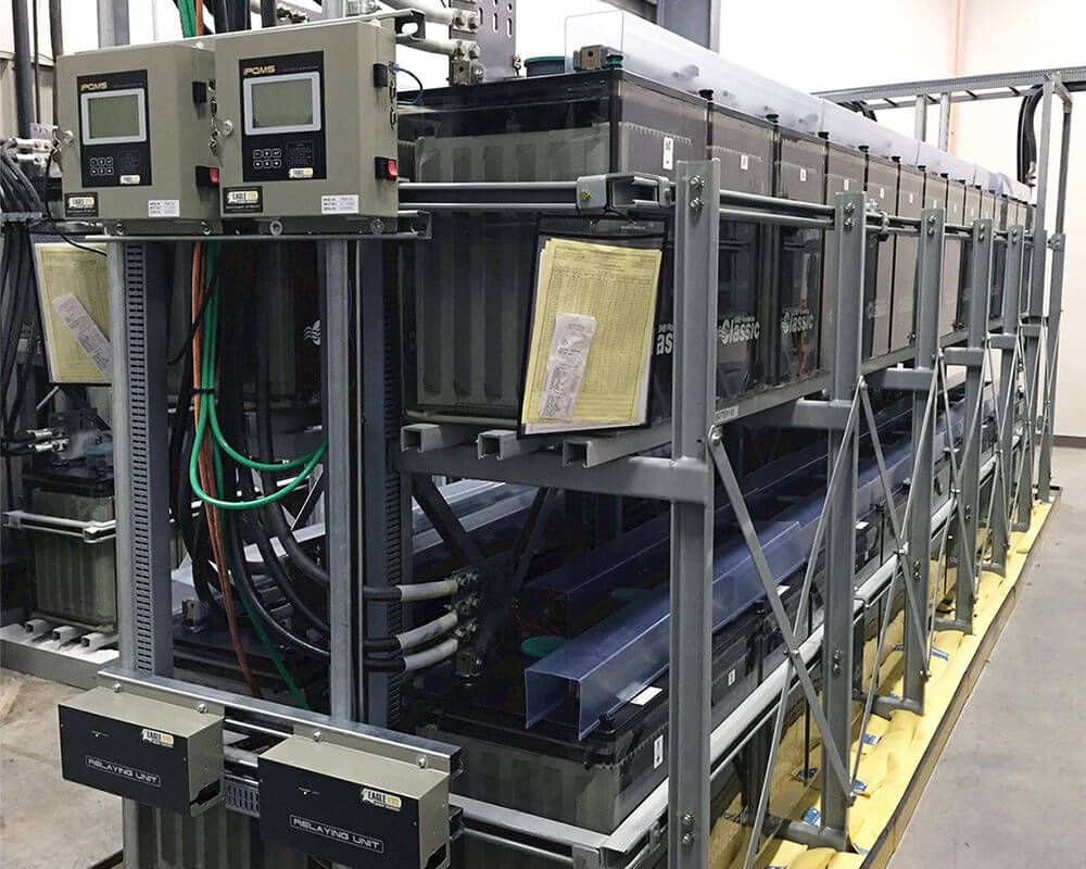 Close shot of racks of batteries in a battery room with Eagle Eye Power Solutions iPQMS battery monitoring system