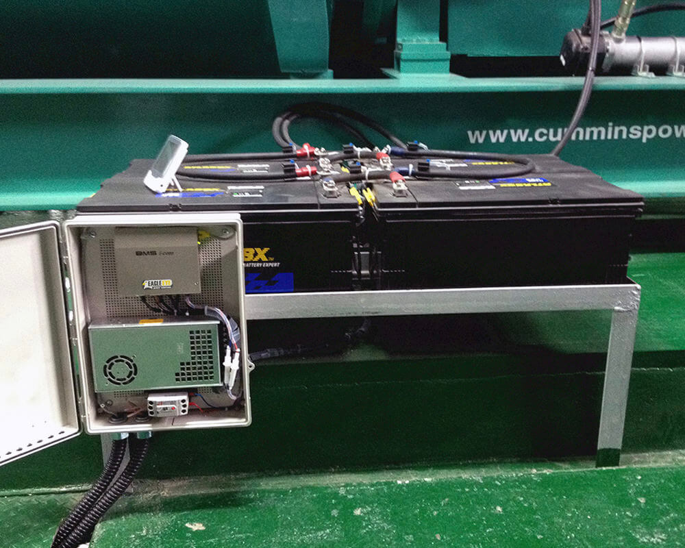Eagle Eye Power Solutions BMS-icom battery monitor attached to two batteries with encased mounted system door open