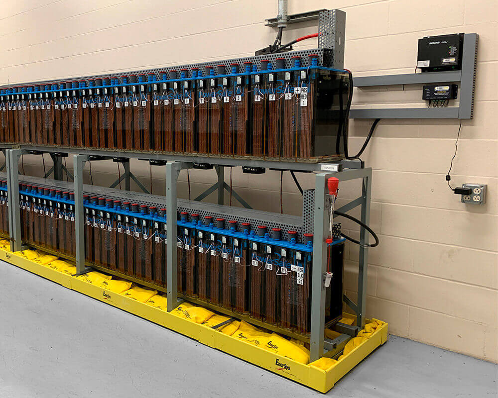 Battery room with two racks of batteries and Eagle Eye Power Solutions BQMS system attached