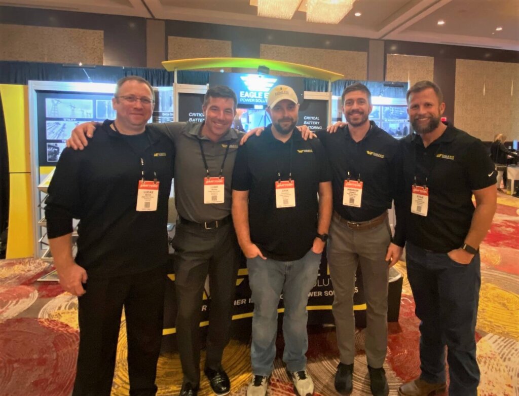 Sales and Service team members in front of the Eagle Eye Powers Solutions booth at a the Battcon tradeshow.