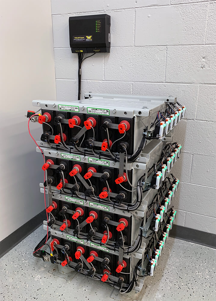 4 stacks of batteries in battery room with Eagle Eye Power Solutions Vigilant battery monitoring system attached