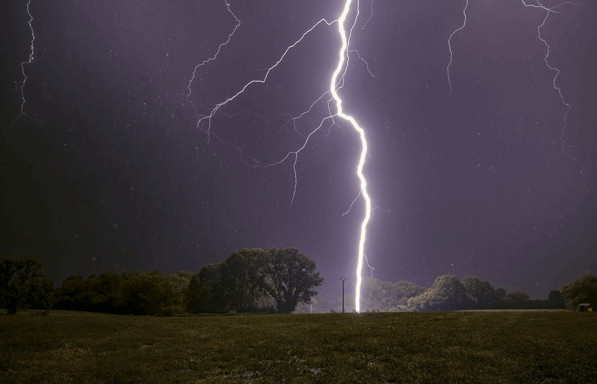 Stormy sky with lightning striking from an open field.