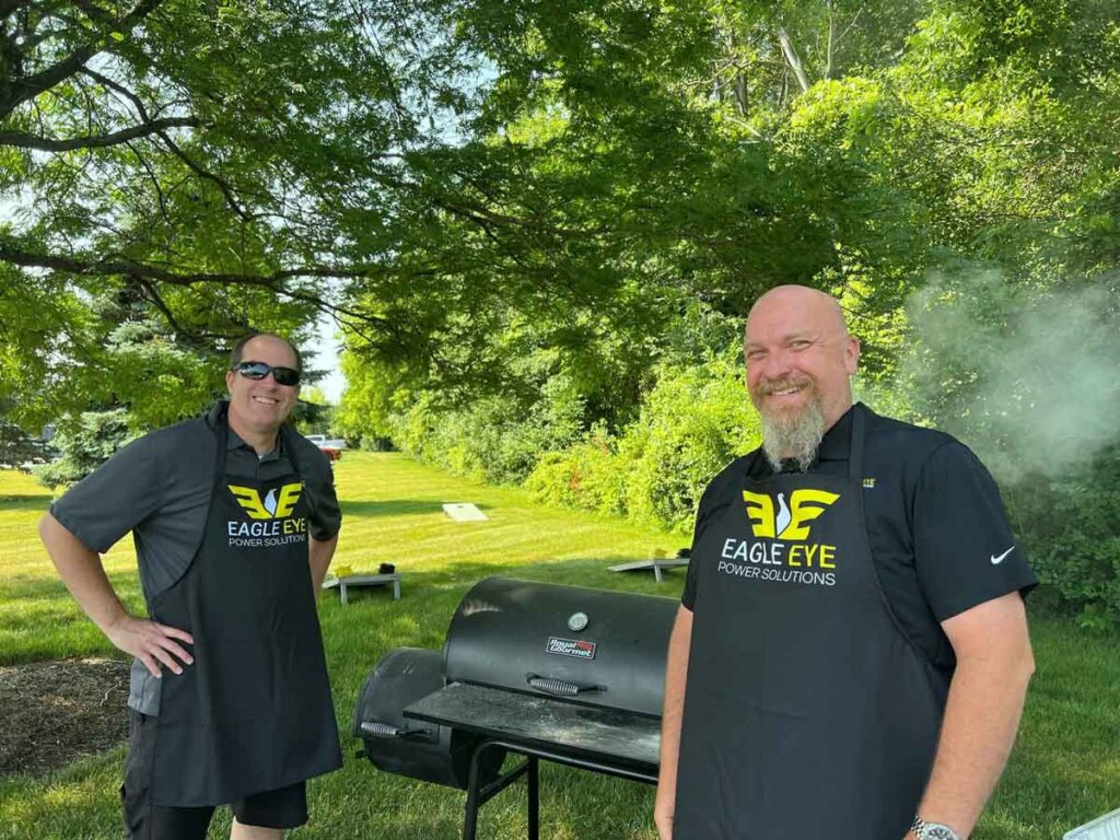 Eagle Eye Power Solutions team members grilling food for a summer event.