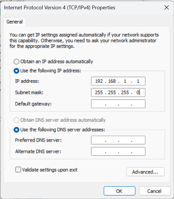 Screenshot of the Internet Protocol Version 4 (TCP/IPv4) Properties window in Windows. The option "Use the following IP address" is selected, with the IP address set to 192.168.1.1 and the subnet mask set to 255.255.255.0. The default gateway and DNS server address fields are left blank. The "Use the following DNS server addresses" option is also selected, but no values are entered. Instructions above the image explain this configuration step for setting up communication with a Vigilant® monitor.