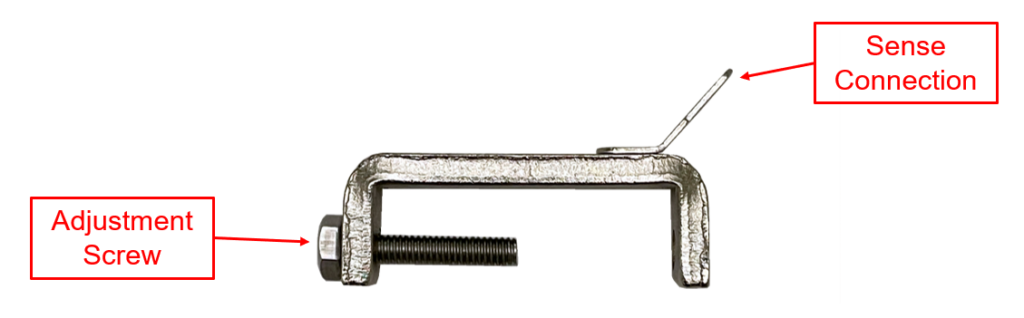 A labeled image of a C-Clamp used for square-post battery terminal installations. The clamp is shown in a side profile, with the adjustment screw identified on the left side for securing the clamp onto the battery post. A tab, labeled as the sense connection, extends upward from the top of the clamp, indicating where the sense lead (red or black) attaches. The clamp is used for connecting sense leads to every cell in a battery system.