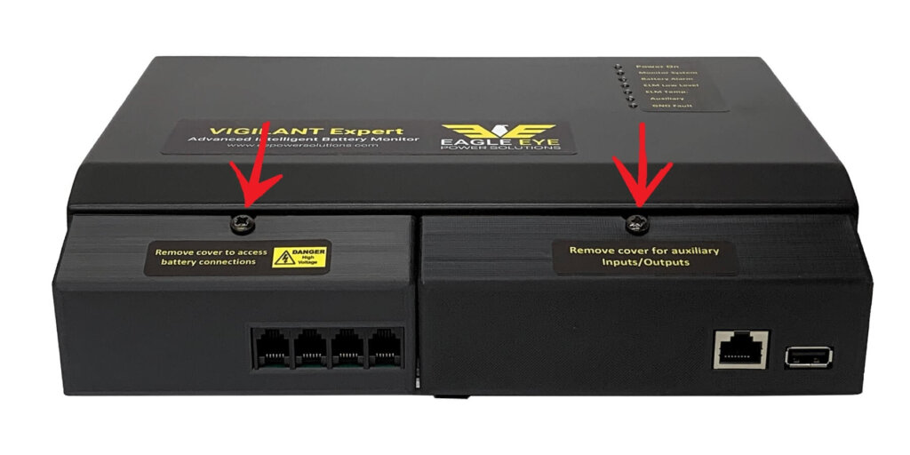 Front view of the Eagle Eye Power Solutions Vigilant® Expert battery monitor with red arrows pointing to the two screws securing the front covers. The left cover provides access to battery connections, and the right cover provides access to auxiliary inputs/outputs. The image supports instructions to loosen (but not fully remove) the screws and pull the covers outward to remove them.