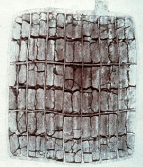 Aged battery plate showing significant grid corrosion, active material breakdown, and visible cracking—typical of natural aging in lead-calcium batteries.