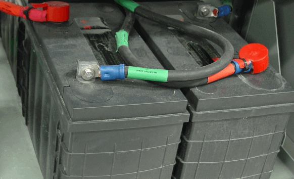 Distorted batteries showing bulging casing caused by positive plate growth, a common aging issue in lead-acid battery cells.