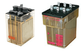 Small to medium size VLA (Vented Lead-Acid) single and multi-cell batteries with transparent casing, showing internal plates and terminals, used for backup power and critical applications.